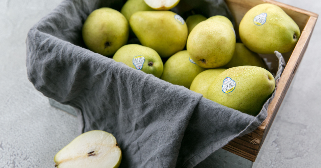 pears in a wooden box with one sliced in half