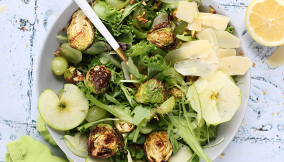 A green salad featuring grapes, granny smith, brussel sprouts, lemon, salt, and pepper.