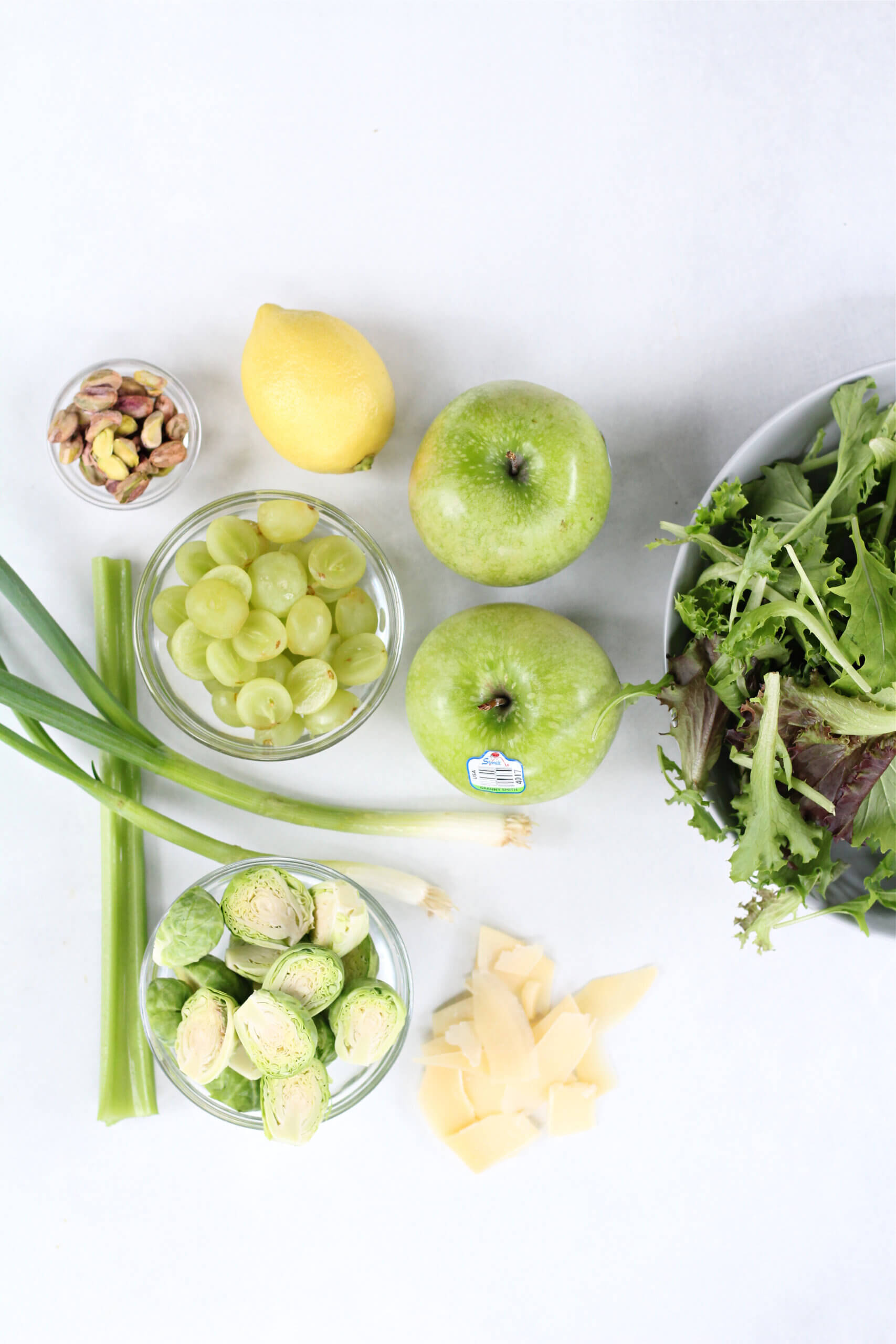 Ingredients for the Ultimate Green Salad- granny smith apples, grapes, green onions, brussel sprouts, mixed greens, lemon,