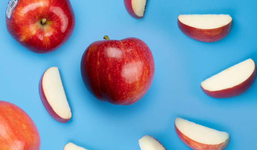 Picture of apple and slices on blue background