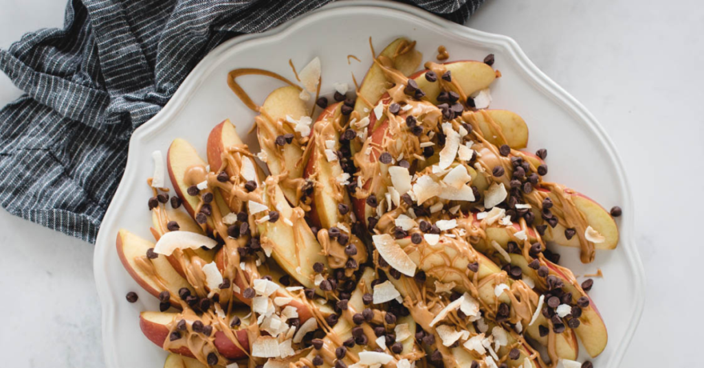 Apple Nachos being served with chocolate chips and coconut flakes