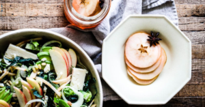 Pickled Apples in a bowl, next to a salad with sliced pickled apples