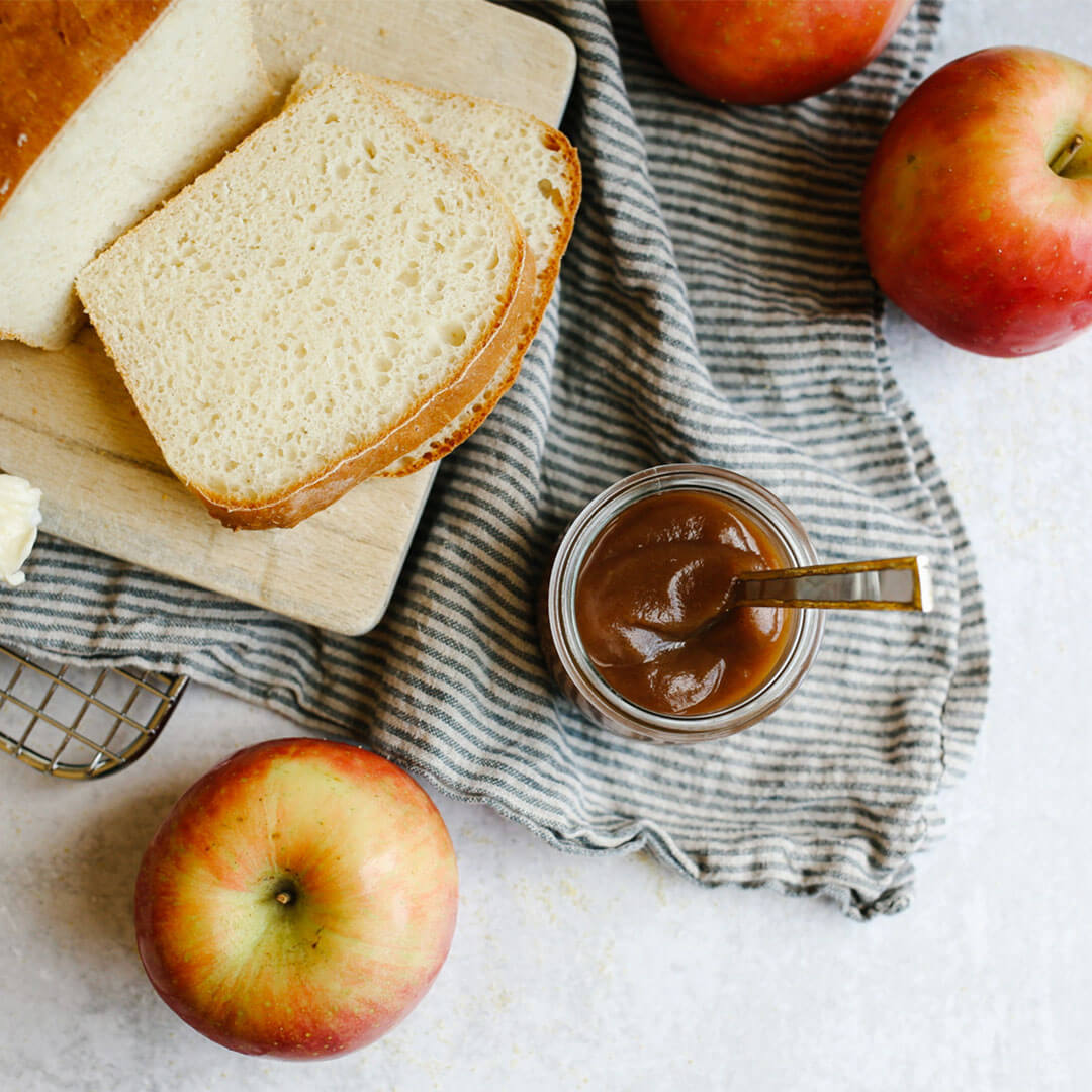Apple butter with English Muffin bread sliced on a serving tray.
