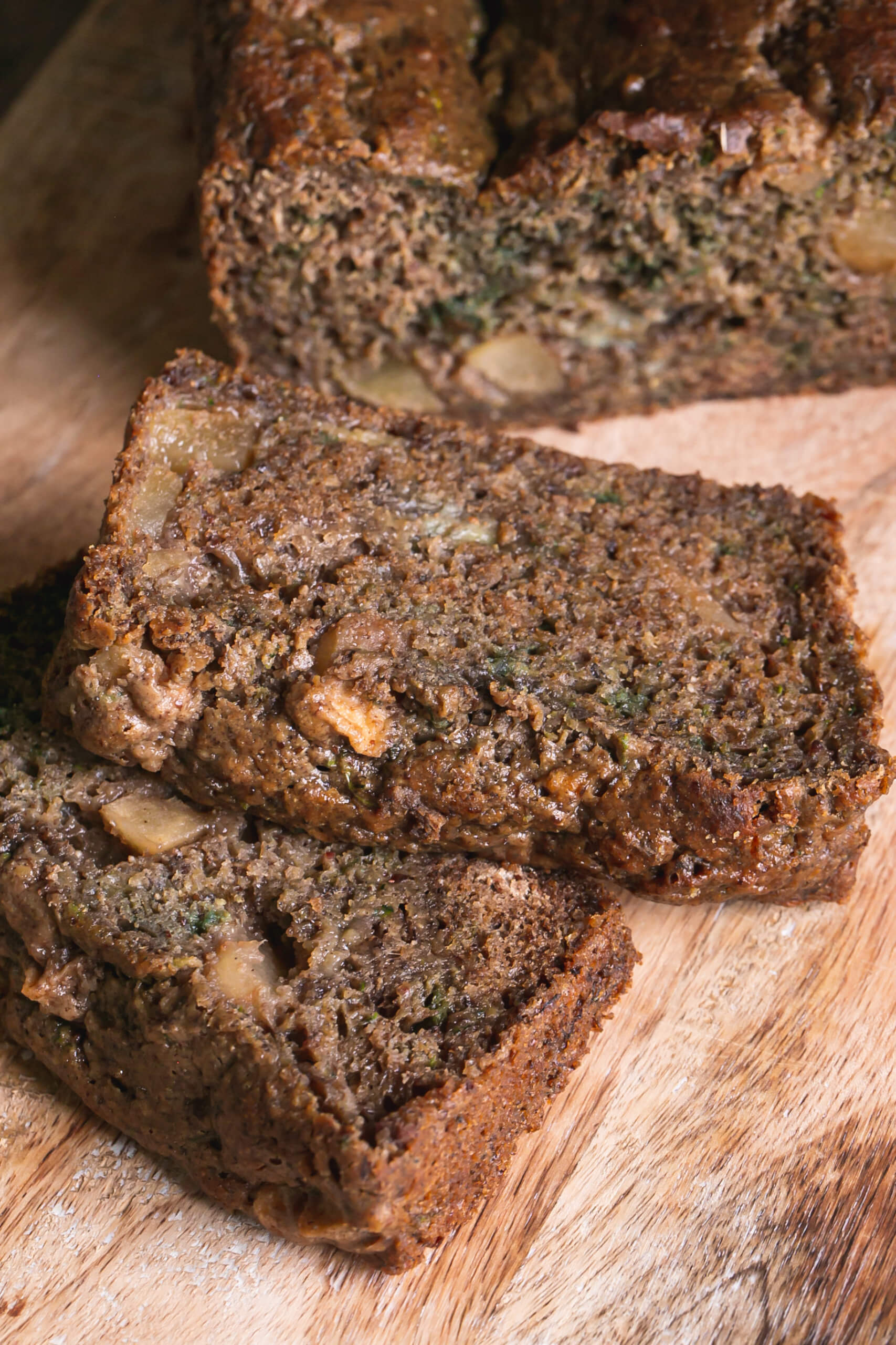 Vegan and Gluten Free Banana Cinnamon Zucchini bread on a cutting board in slices.