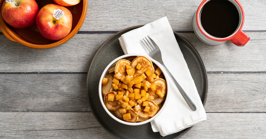 Bowl of mini pancakes with chunky apple syrup