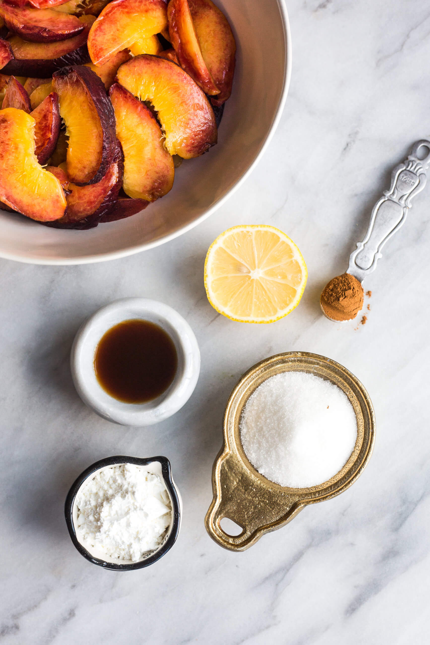 ingredients for peach pie- peaches, sugar, lemon, vanilla, flour