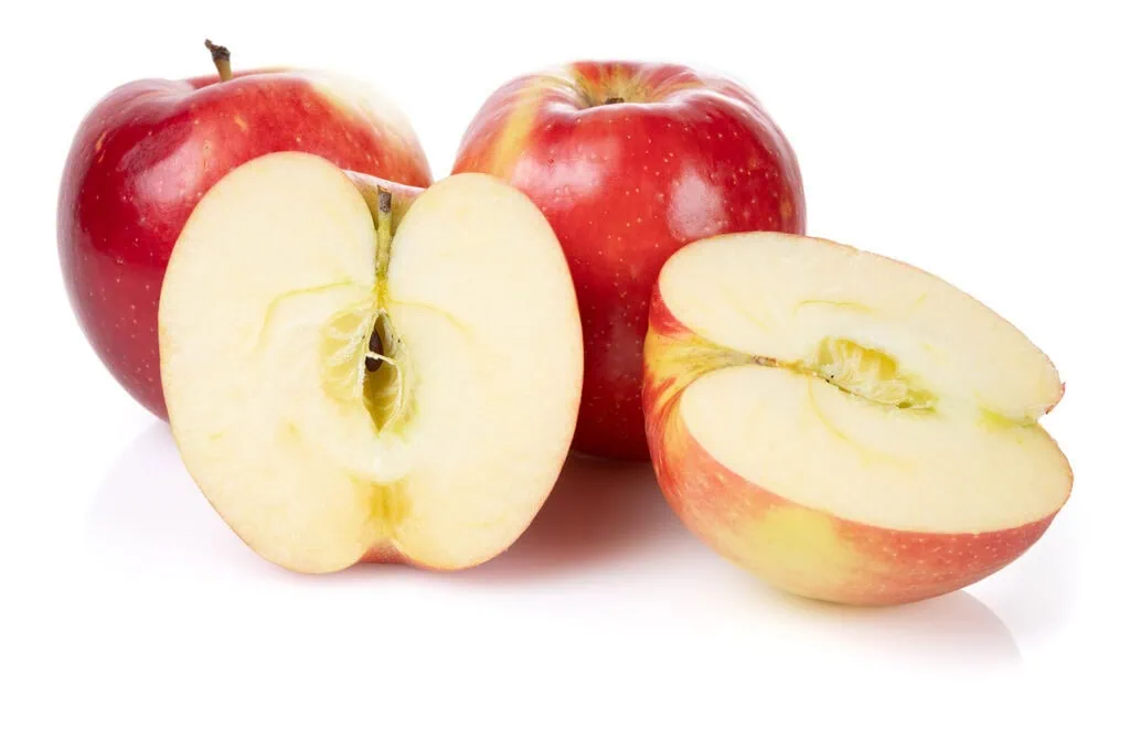 Two whole red apples and a sliced apple showing juicy interior.
