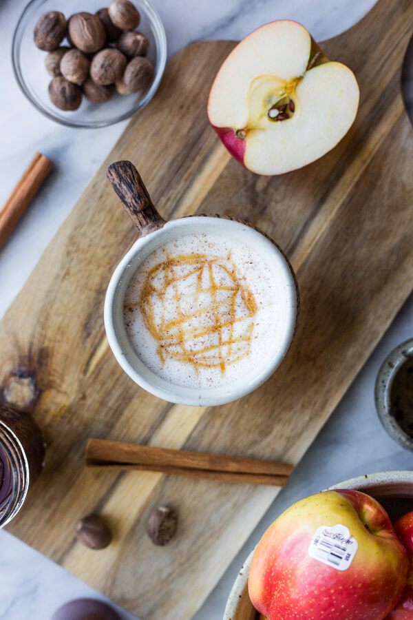 Completed Apple Crisp Macchiato with ingredients surrounding the cup