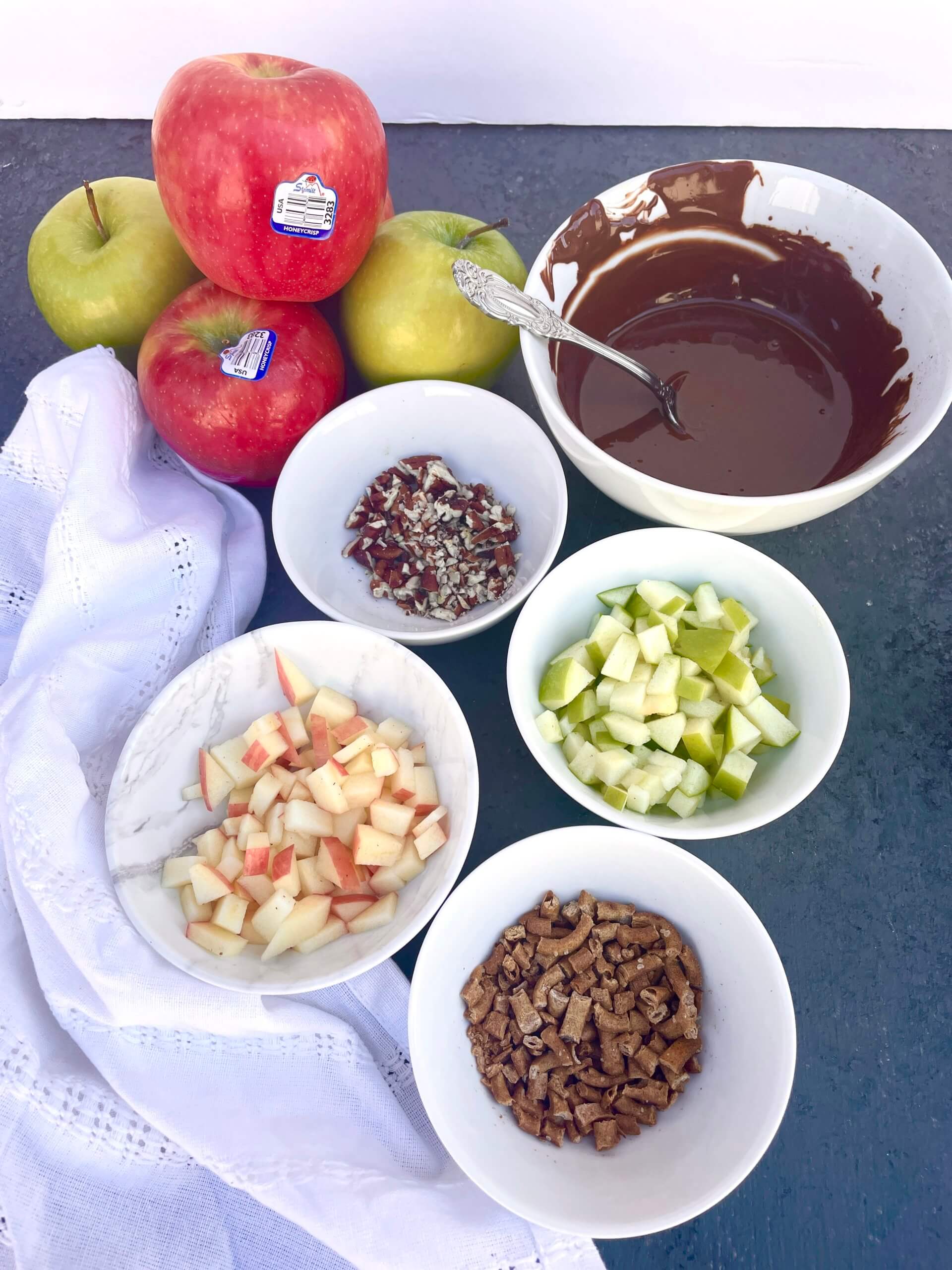 Apples, Caramel, pretzels, and almonds in ingredients bowls