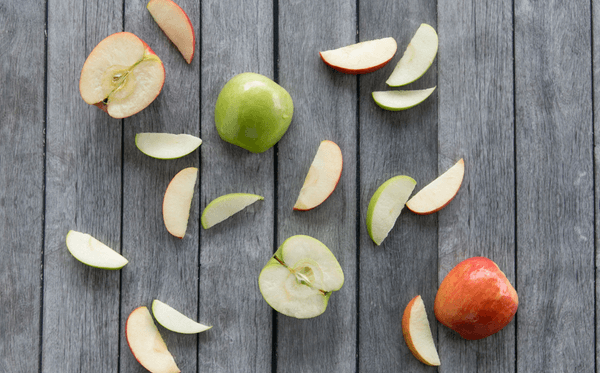 Cut red and green apples with slices displayed.