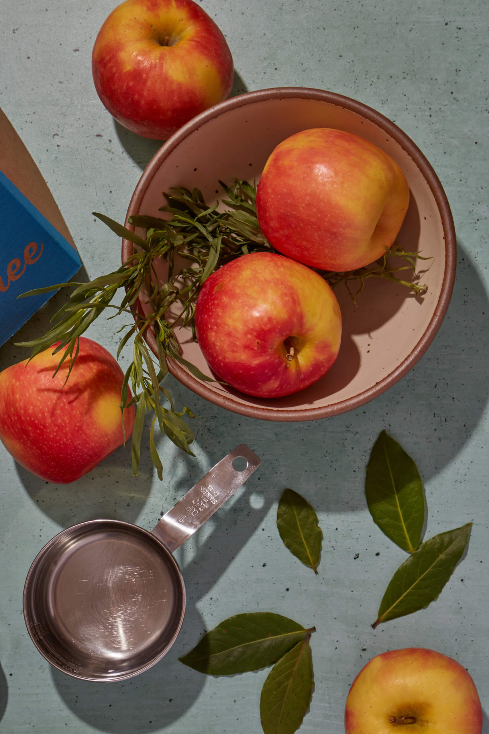 Ingredients to make apple cider- apples, bay leaf, Rosemary, vinegar.