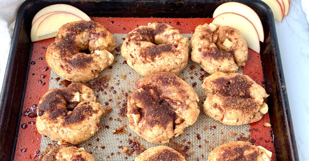 Apple Crunch bagels with apple slices on the baking sheet.