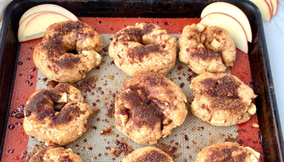 Apple Crunch bagels with apple slices on the baking sheet.