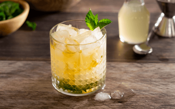 A Pear Mint Julep with mint garnish on a counter top.