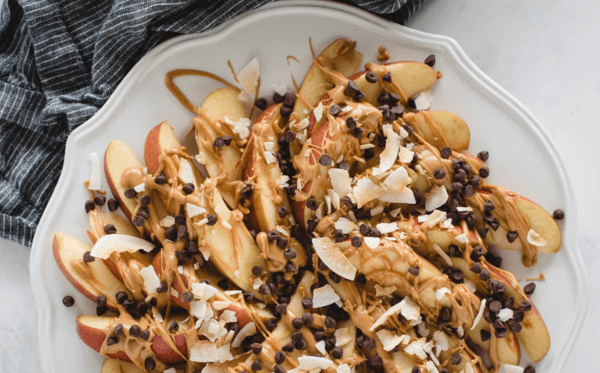 Apple slices drizzled with peanut butter and chocolate chips to create apple nachos