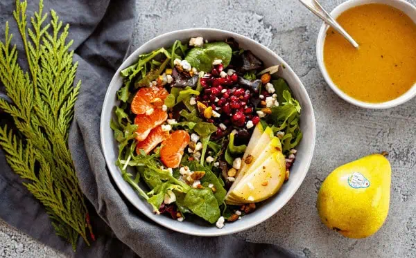 A winter pear salad with pomegranates, mandarin oranges, and pistachios