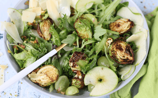 Green salad in a bowl with apple, fennel, brussel sprouts, and grapes