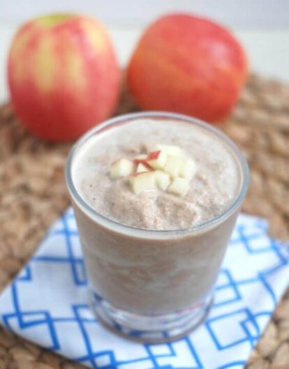 Chocolate peanut butter apple recovery smoothie with apple pieces on top.