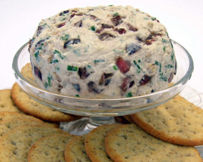 Cherry and chocolate chip cookie dough ice cream in a glass dish with cookies around it.