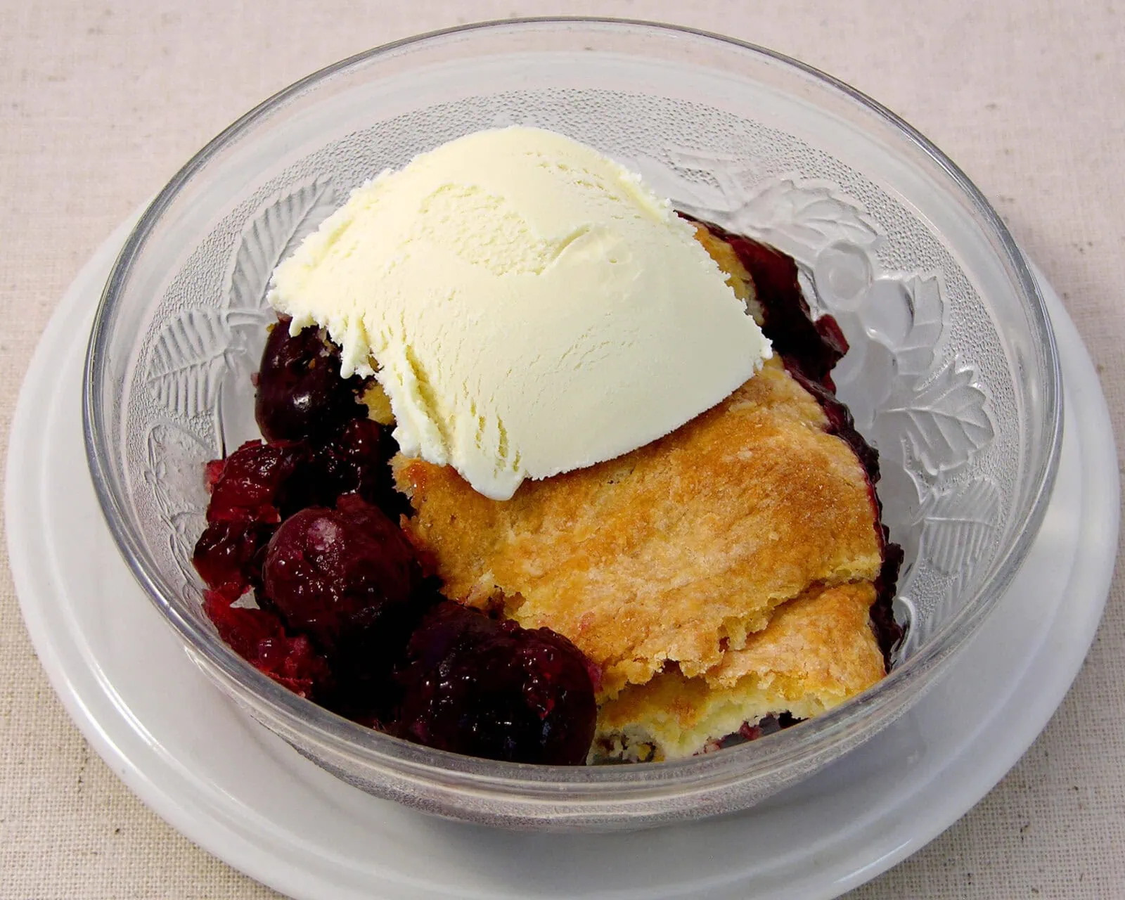 Old Fashioned Cherry Slump with ice cream in a glass bowl.