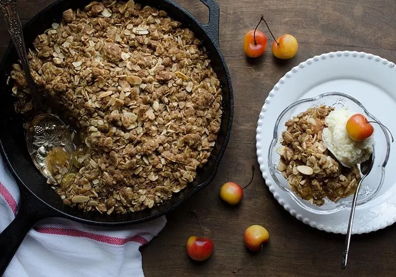 Freshly baked Rainier cherry crisp with cherries on top and a scoop of ice cream.