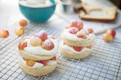 Mini Cherry Shortcakes with Rainier cherries and whipped cream on a cooling rack.