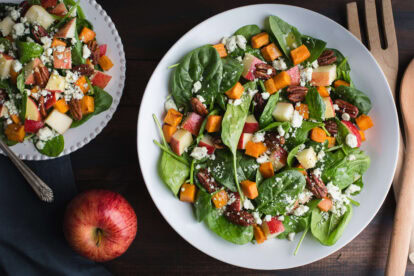 Fresh spinach salad with roasted sweet potatoes, apples, pecans, and feta cheese.