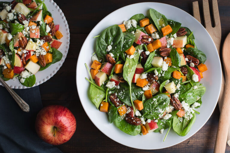 Fresh spinach salad with roasted sweet potatoes, apples, pecans, and feta cheese.