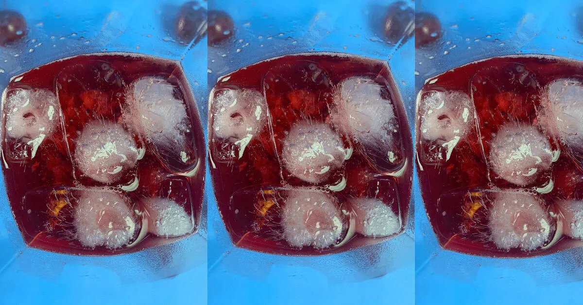 Smashed Shirley Temple cocktail with ice and cherry in a glass.