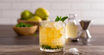 Refreshing Pear Mint Julep cocktail with mint leaves and ice in a glass.