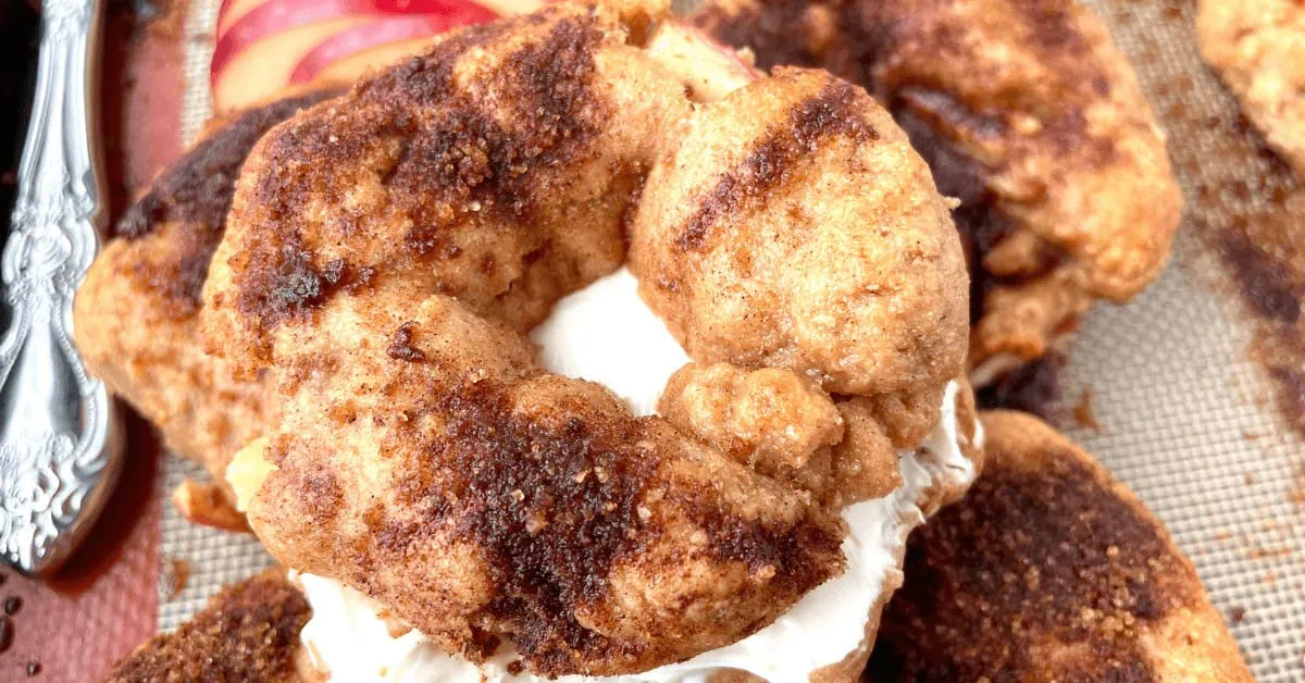 Close-up of a cinnamon sugar bagel with cream cheese on a baking sheet.