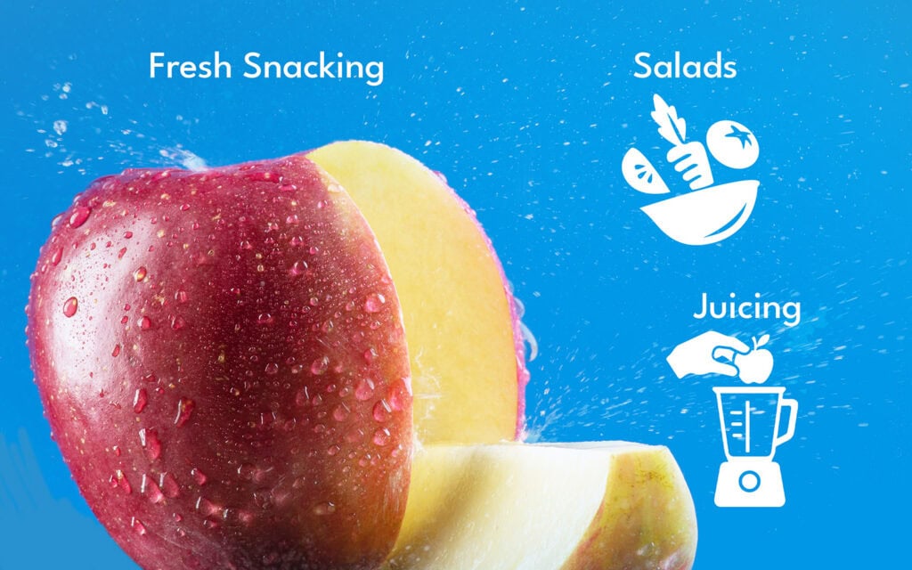 Close-up of a fresh Fuji apple with water droplets, ideal for snacking and salads.