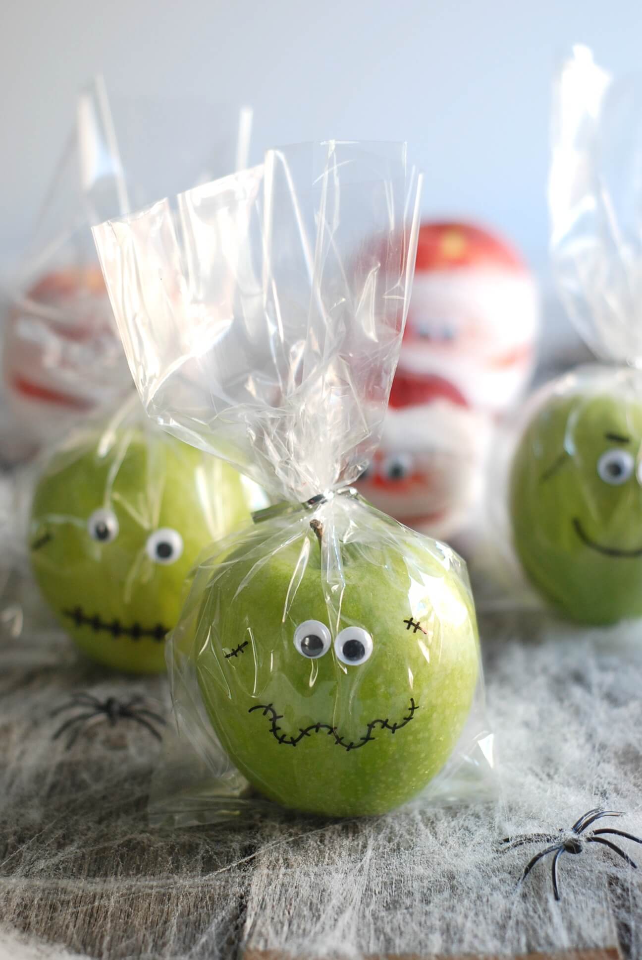 Green apple decorated as a spooky skull for Halloween party favors.
