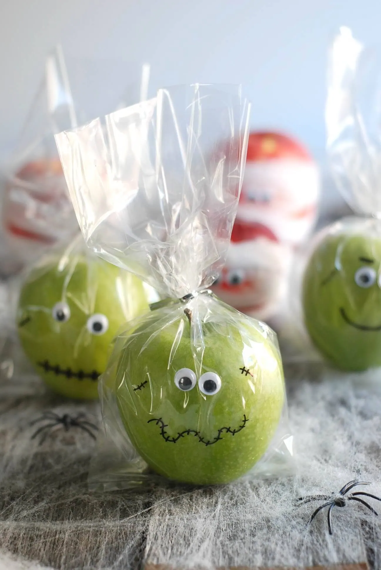 Green apple decorated as a spooky skull for Halloween party favors.