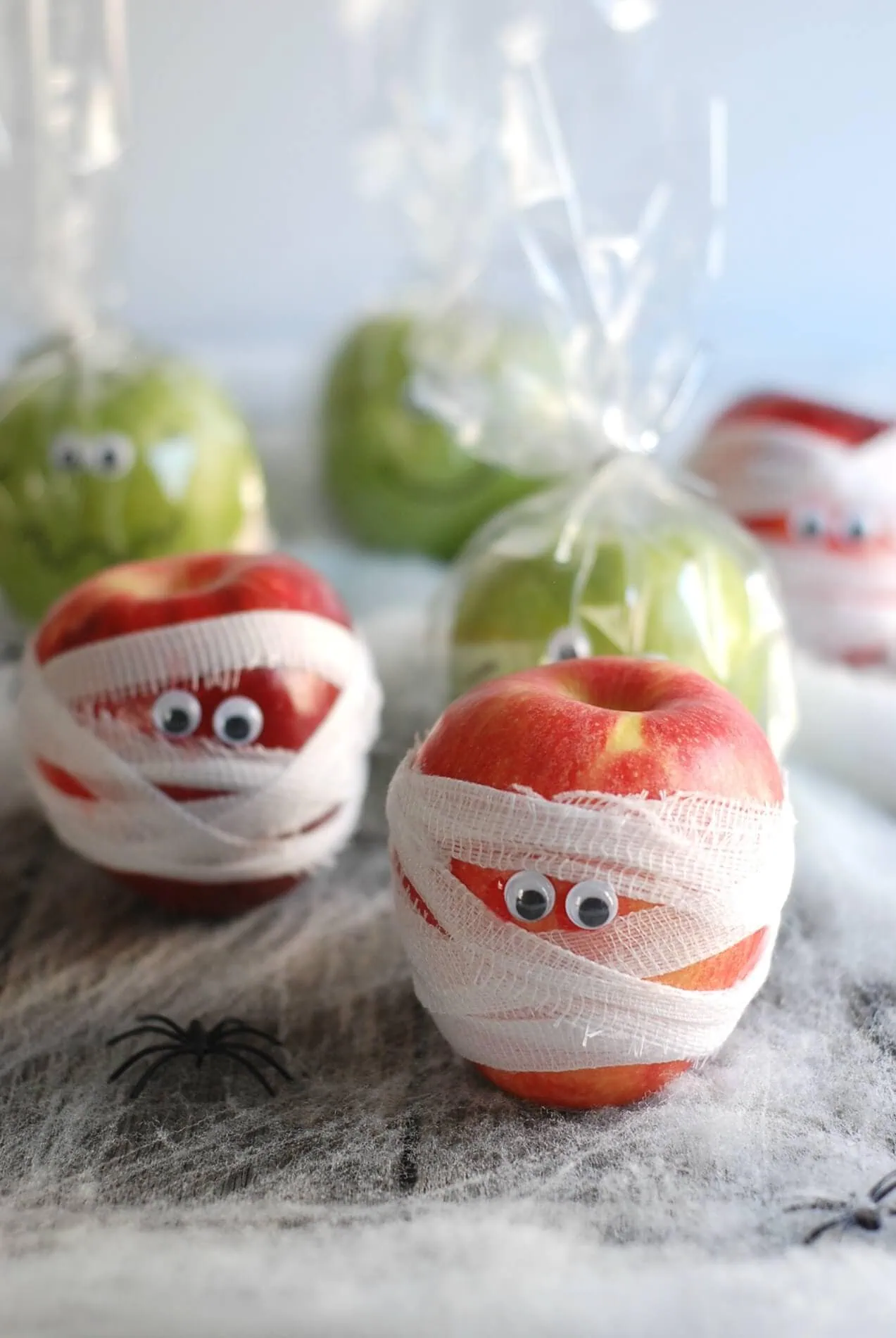 Apple decorated with googly eyes and bandages for Halloween party favors.