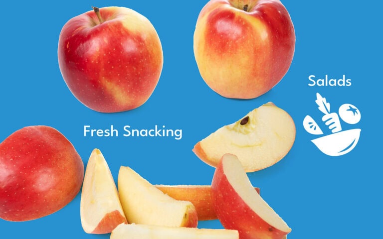Fresh SweeTango apples with slices on a blue background for healthy snacking and salads.