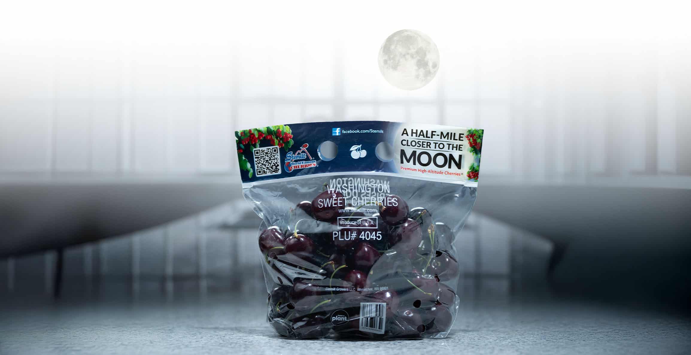 Stemilt Moon Cherries in a clear bag with moon and night sky background.
