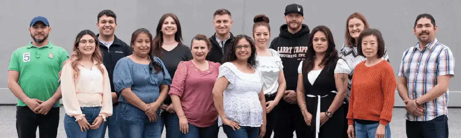 Group of diverse Stemilt employees posing outdoors for a team photo.